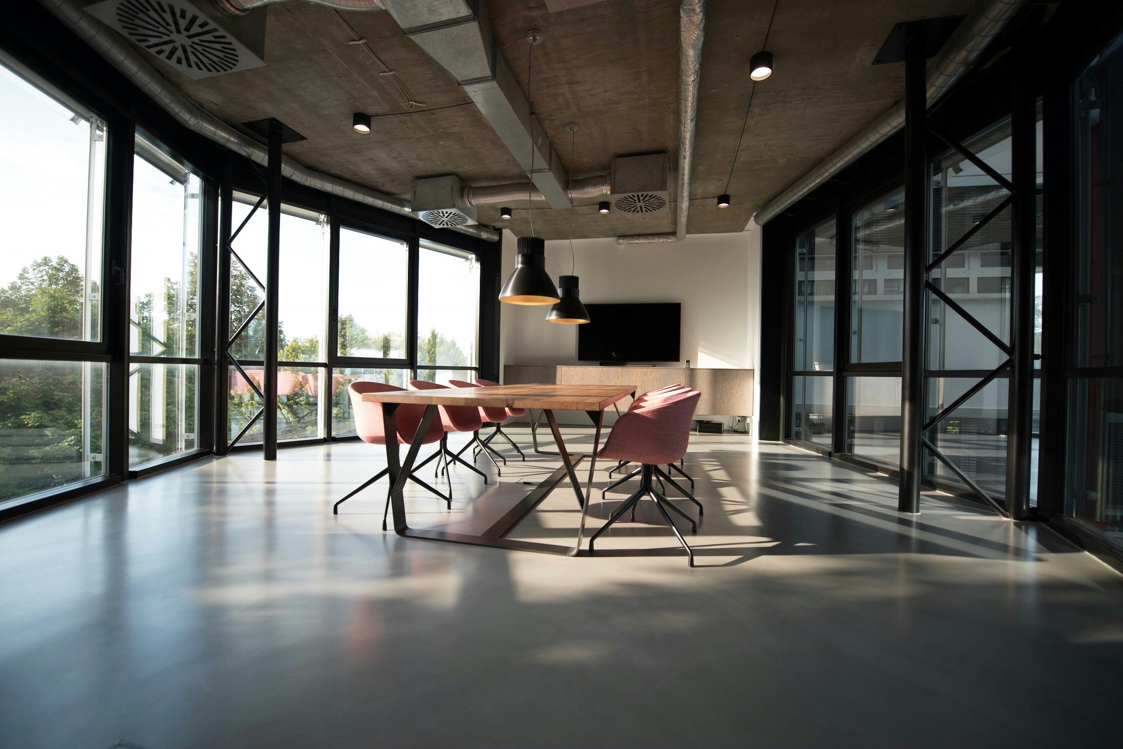 Modern meeting room with a wooden table and floor-to-ceiling windows